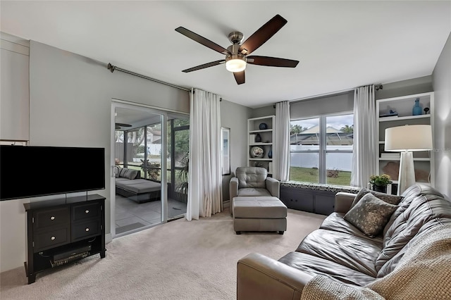 carpeted living room with ceiling fan