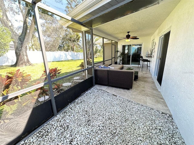 sunroom / solarium featuring beam ceiling and ceiling fan