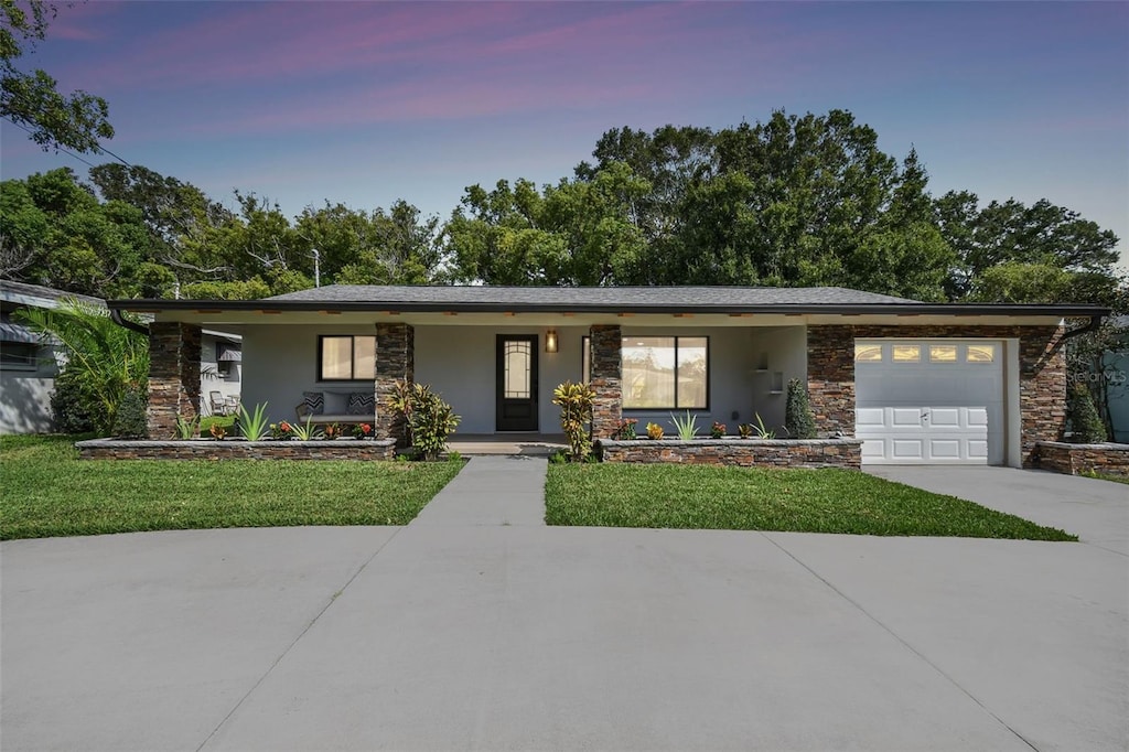 view of front of home with a garage and a yard