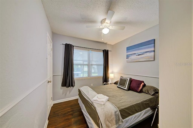 bedroom with dark hardwood / wood-style floors, a textured ceiling, and ceiling fan