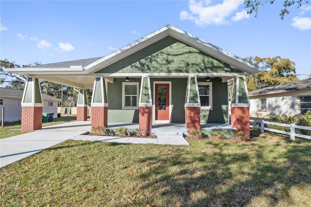 craftsman inspired home featuring covered porch and a front lawn