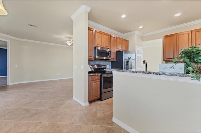 kitchen with ceiling fan, crown molding, dark stone counters, decorative backsplash, and appliances with stainless steel finishes