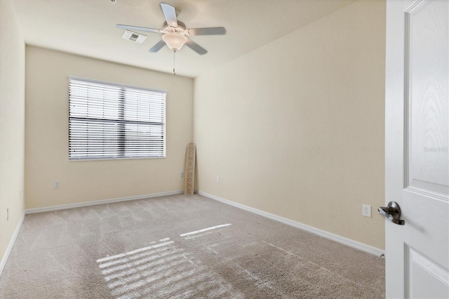 spare room with ceiling fan and light carpet