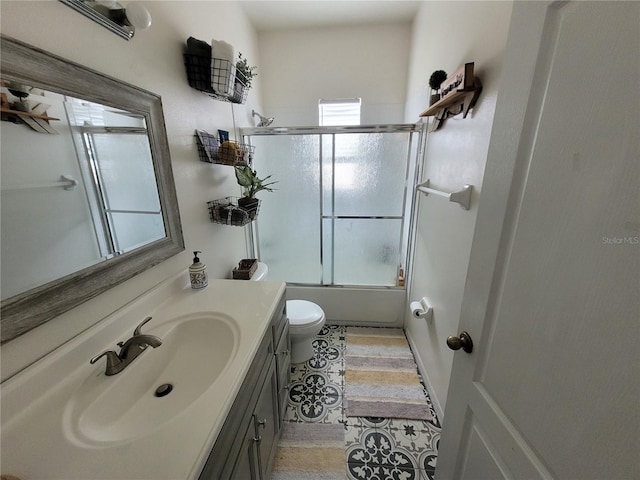 full bathroom with vanity, toilet, tile patterned floors, and combined bath / shower with glass door