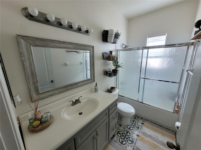 full bathroom featuring vanity, enclosed tub / shower combo, and toilet