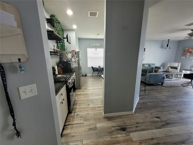 kitchen with hardwood / wood-style floors, ceiling fan, white cabinetry, pendant lighting, and stainless steel appliances