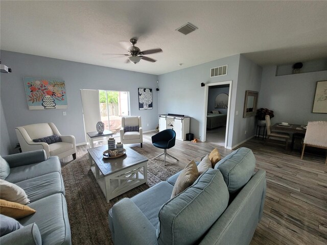 living room featuring ceiling fan and dark hardwood / wood-style flooring