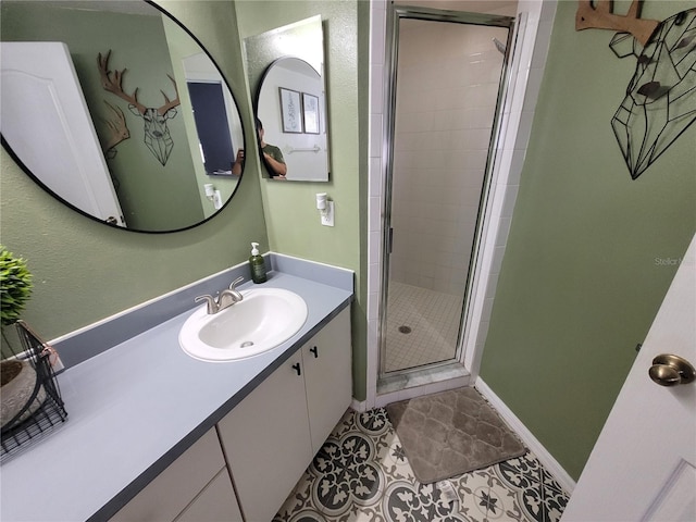 bathroom with a shower with door, vanity, and tile patterned flooring