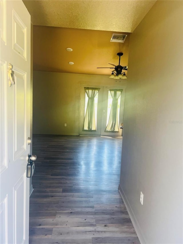 empty room featuring ceiling fan, wood-type flooring, and a textured ceiling