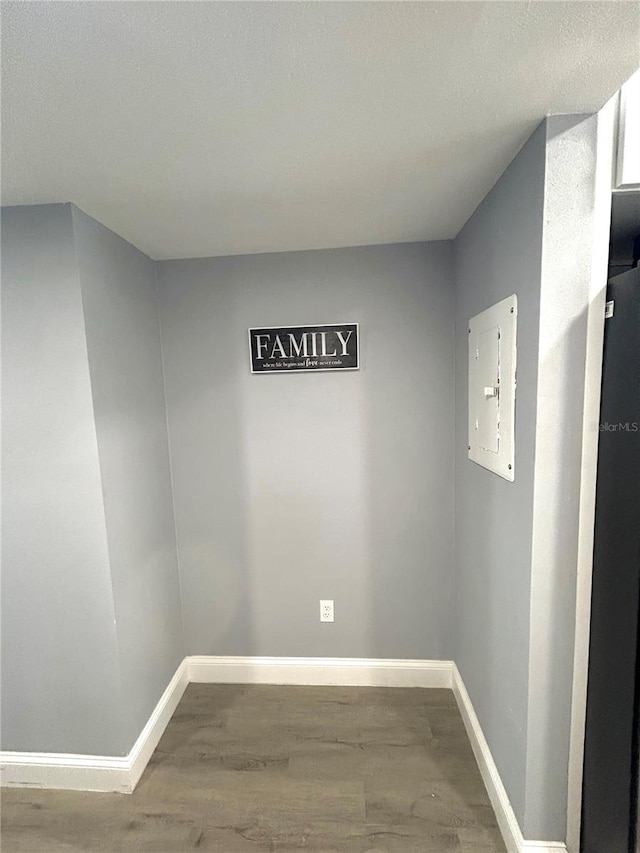 spare room featuring hardwood / wood-style floors, electric panel, and a textured ceiling