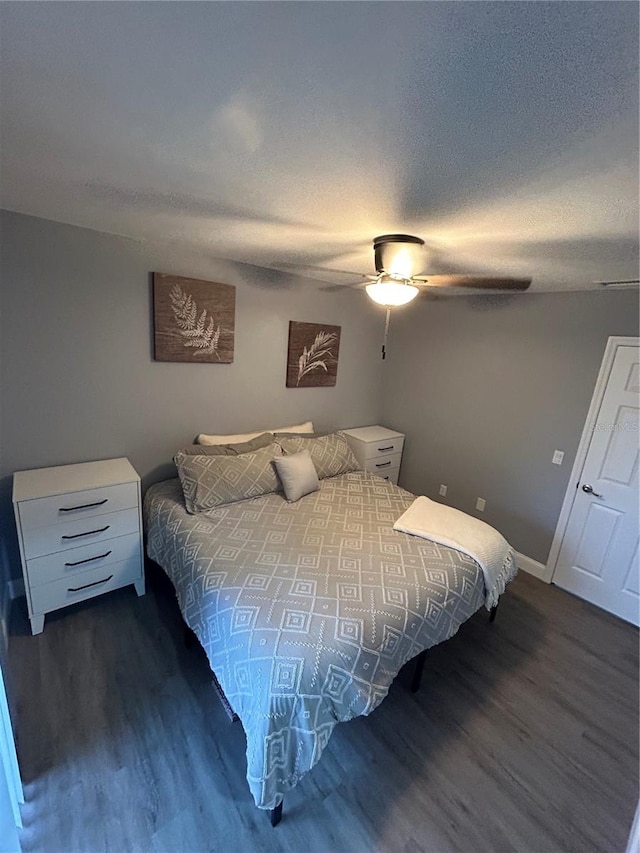 bedroom featuring a textured ceiling, wood-type flooring, and ceiling fan