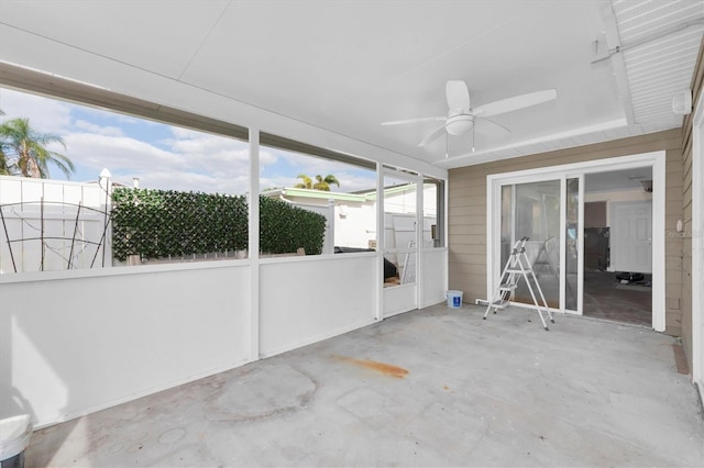 unfurnished sunroom with ceiling fan