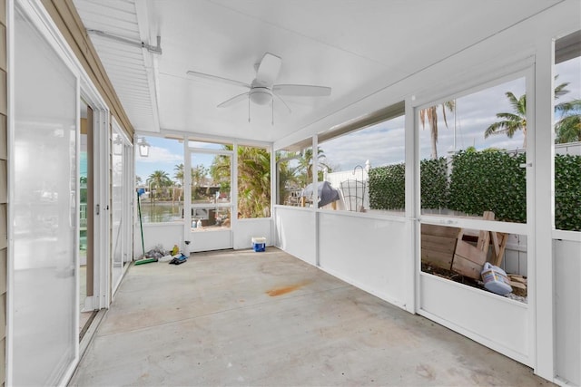 unfurnished sunroom featuring ceiling fan