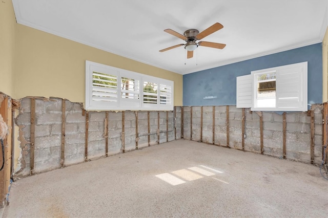 basement with ceiling fan and ornamental molding