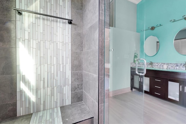 bathroom with a shower, tile patterned flooring, and vanity