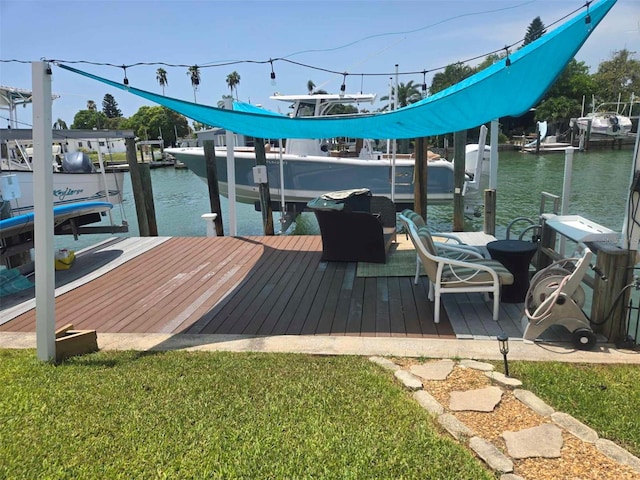 view of dock with a yard and a water view