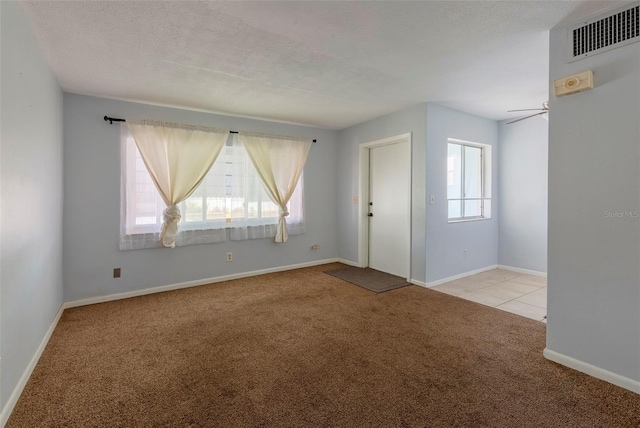 unfurnished room featuring ceiling fan, a textured ceiling, and light colored carpet