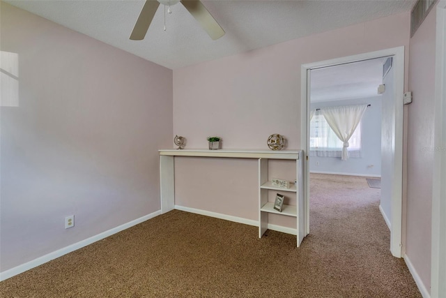 interior space with ceiling fan, carpet flooring, and a textured ceiling