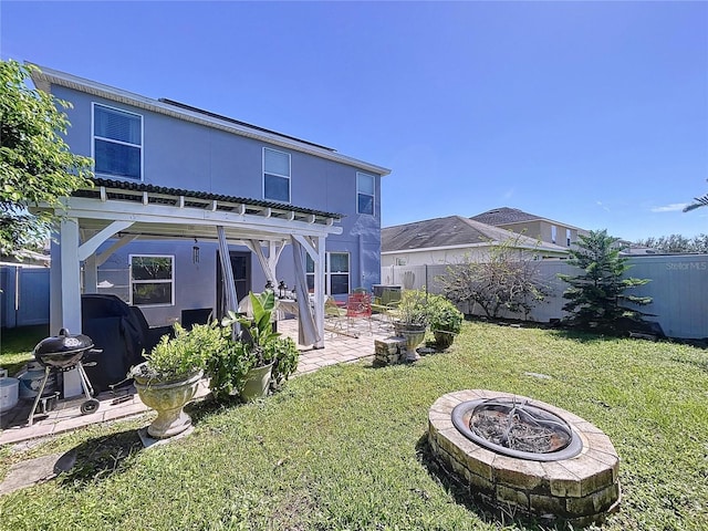 back of property featuring a pergola, a patio area, a lawn, and a fire pit