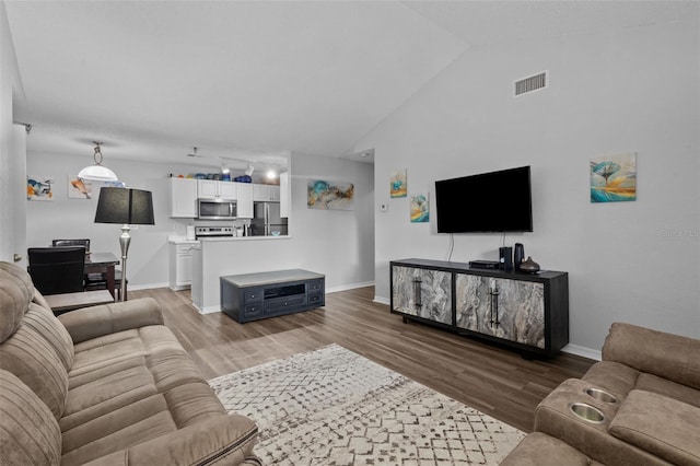 living room featuring hardwood / wood-style flooring and vaulted ceiling