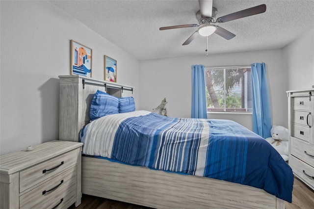 bedroom with a textured ceiling, dark wood-type flooring, and ceiling fan