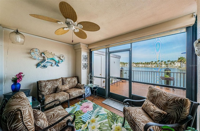 sunroom with a water view and ceiling fan