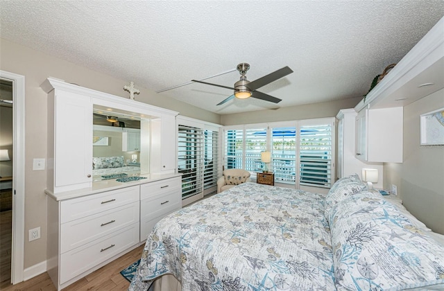 bedroom featuring ceiling fan, a textured ceiling, and light hardwood / wood-style flooring