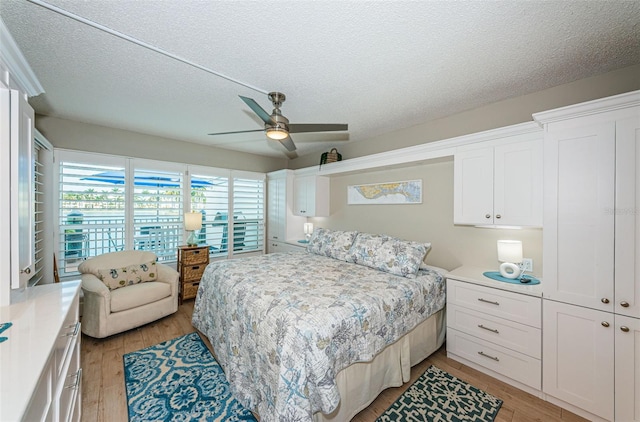 bedroom featuring light hardwood / wood-style floors, a textured ceiling, and ceiling fan