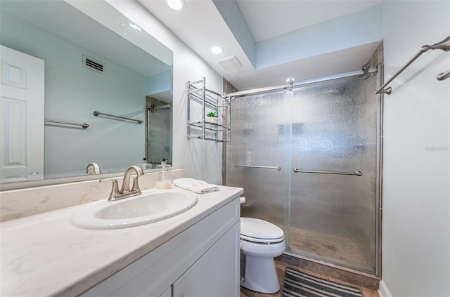 bathroom with toilet, an enclosed shower, and vanity