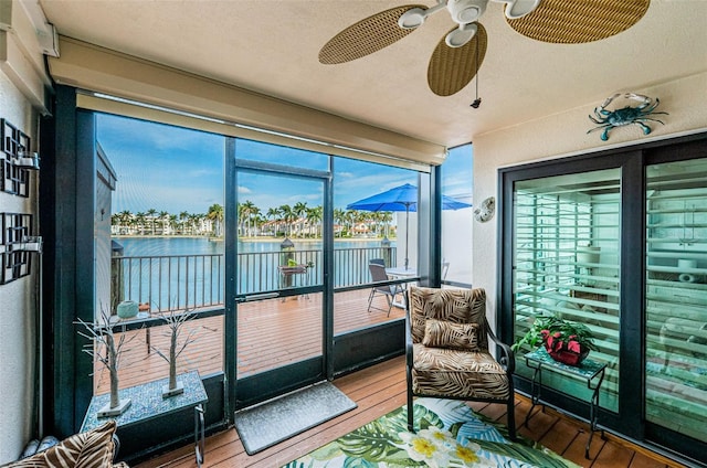 sunroom with a water view and ceiling fan