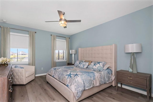 bedroom with hardwood / wood-style floors, multiple windows, and ceiling fan