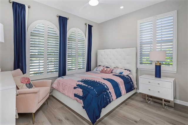 bedroom with light hardwood / wood-style floors, multiple windows, and ceiling fan