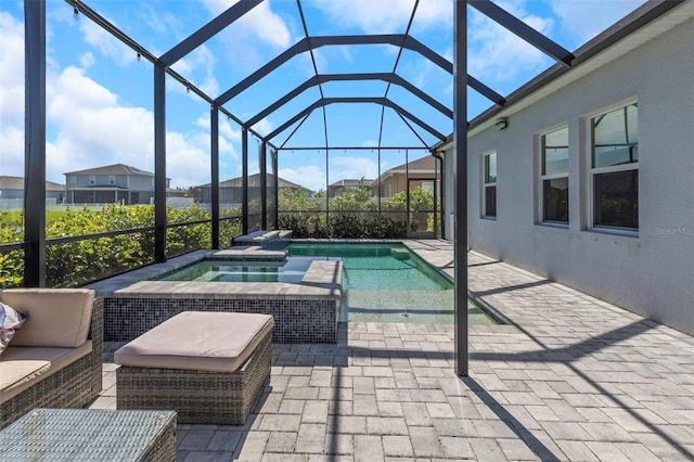 view of pool featuring a patio, an in ground hot tub, and glass enclosure