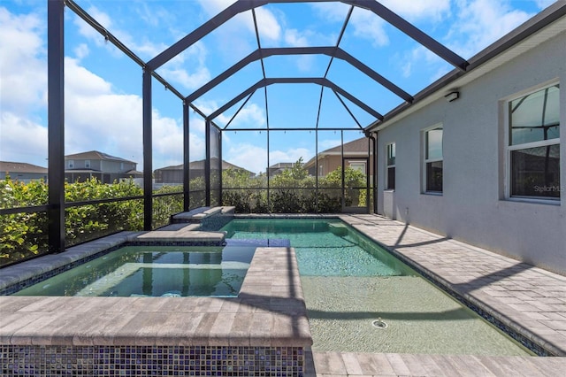 view of swimming pool featuring an in ground hot tub, a patio area, and glass enclosure