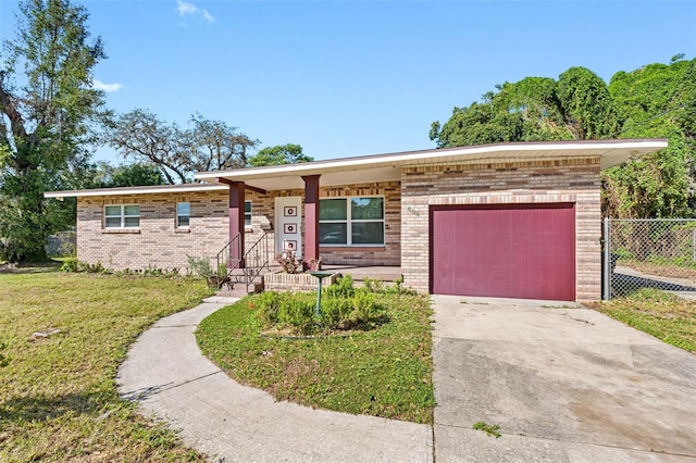 single story home featuring a front yard and a garage