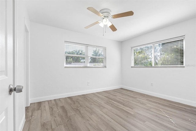 empty room with ceiling fan and light hardwood / wood-style flooring