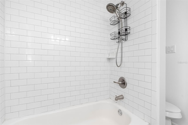 bathroom with toilet and tiled shower / bath combo