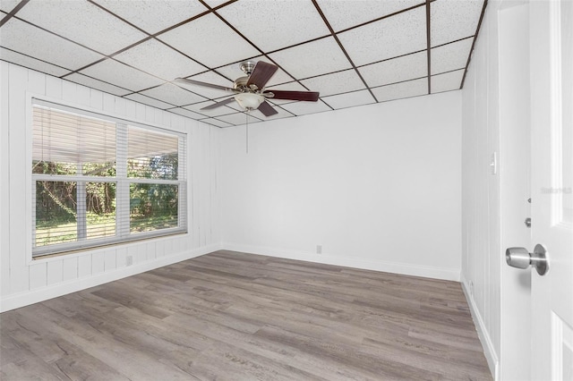 spare room with a drop ceiling, wood-type flooring, and ceiling fan