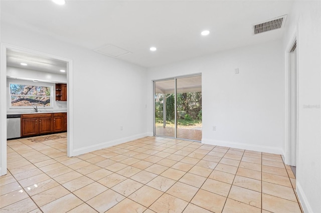 tiled spare room with a healthy amount of sunlight and sink