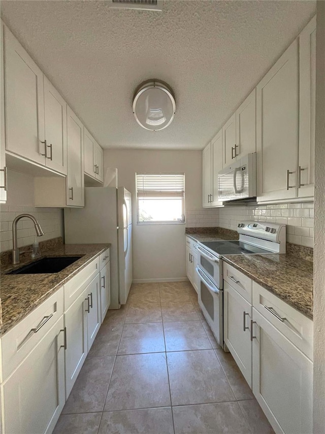 kitchen featuring white cabinetry, sink, and white appliances