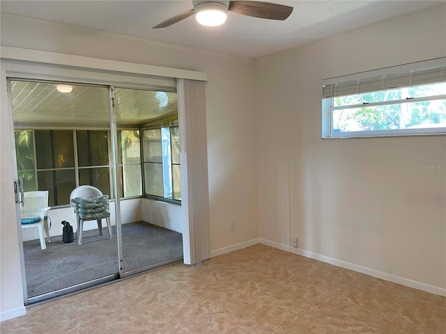 empty room featuring light tile patterned flooring and ceiling fan