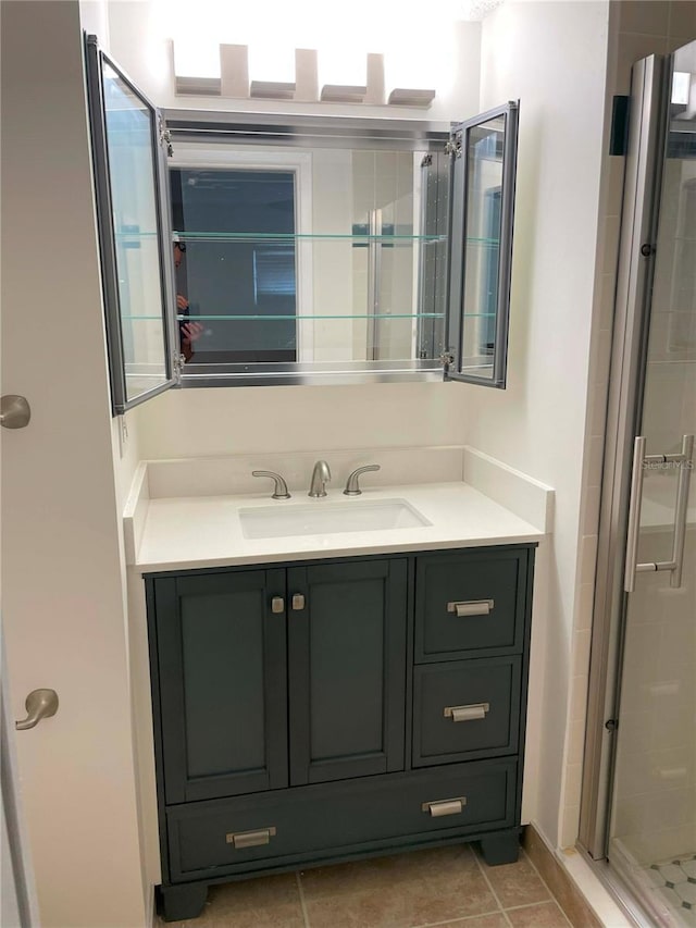 bathroom featuring vanity, a shower with shower door, and tile patterned flooring