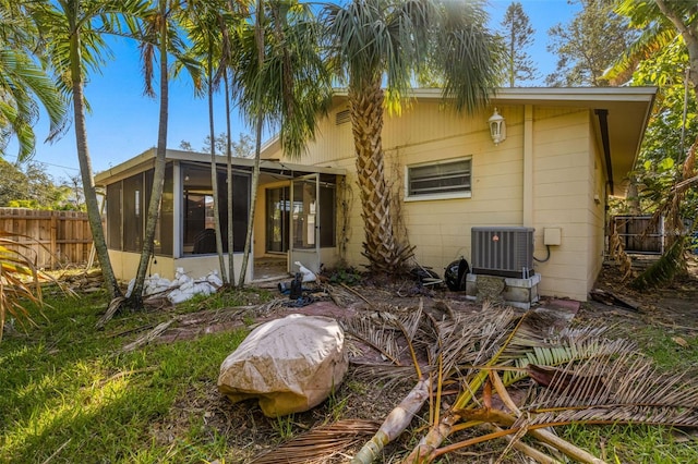 rear view of house with cooling unit and a sunroom