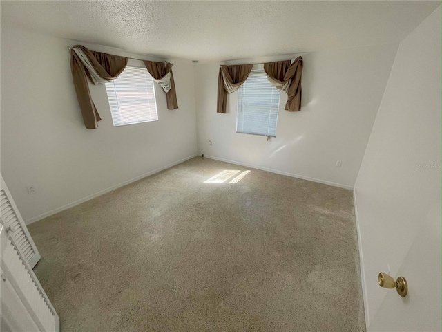 carpeted empty room with a textured ceiling