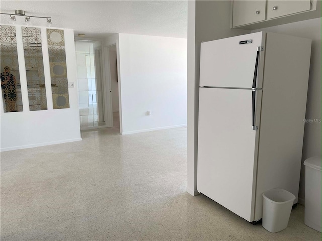 kitchen with a textured ceiling and white refrigerator