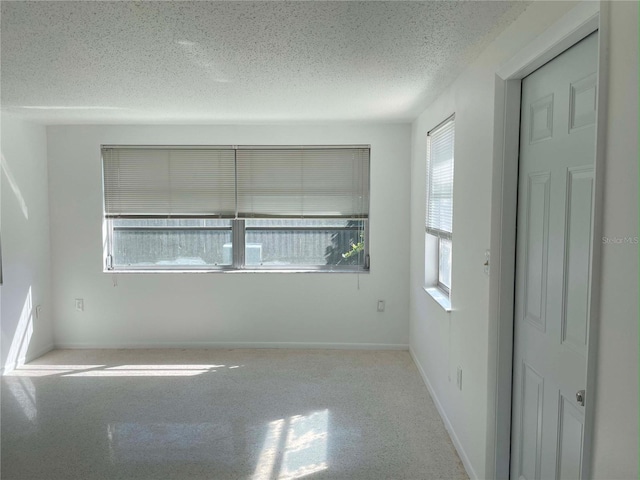 empty room featuring a healthy amount of sunlight and a textured ceiling