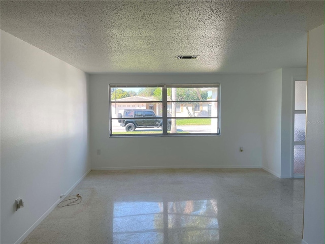 unfurnished room featuring a textured ceiling