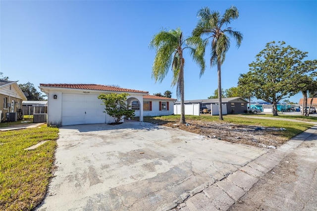 view of front of house featuring a front lawn, central AC, and a garage