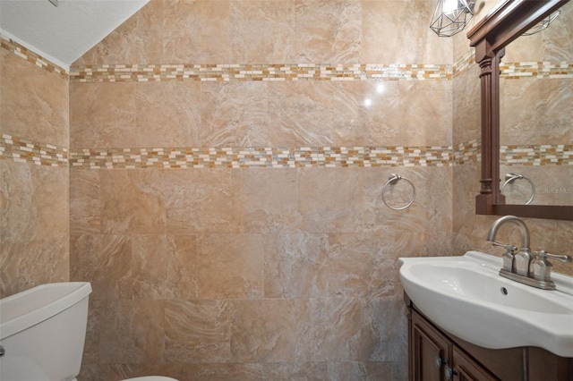 bathroom with vanity, ornate columns, toilet, and tile walls