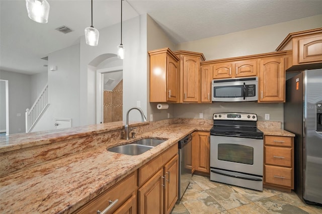 kitchen featuring hanging light fixtures, sink, light stone countertops, appliances with stainless steel finishes, and a textured ceiling